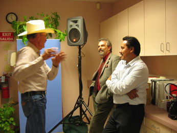 Earl talking with David and Hector by speaker infront of cupboards at Headstart building